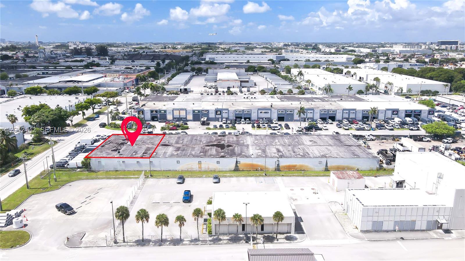 An aerial view shows a rectangular industrial warehouse building with a flat roof and parking — 5500 NW 74th Ave, Miami FL 33166, MIAMI, FL