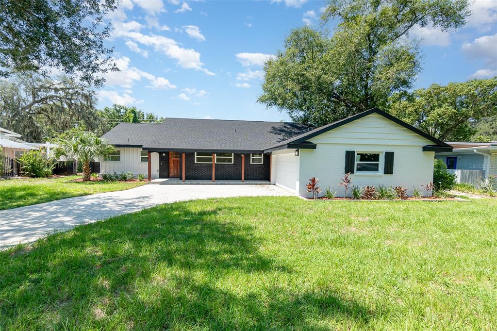A single-story house with a white brick exterior, black roof, and a paved driveway — 1770 ALGONQUIN TRAIL, MAITLAND, FL
