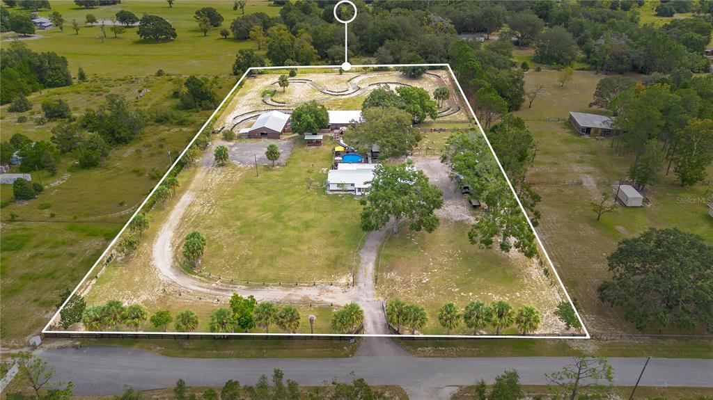 An aerial view shows a rural property with a house, pool, outbuildings, and a dirt track — 32708 GERE LANE, SORRENTO, FL