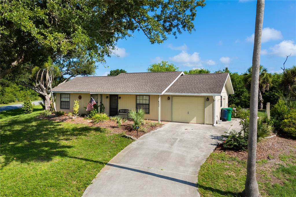 A single-story house with light siding, a shingled roof, and an attached garage — 6232 ROBERTA DRIVE, ENGLEWOOD, FL