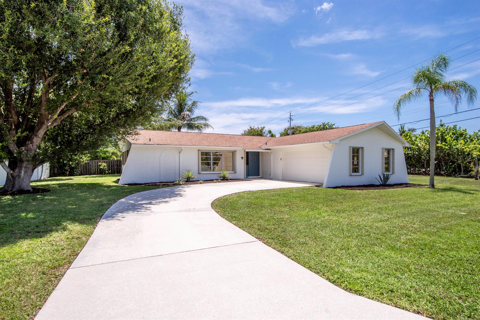 A single-story white house with a curved driveway, a large tree, and a palm tree — 18020 Palm Point Drive, Jupiter FL 33458, JUPITER, FL