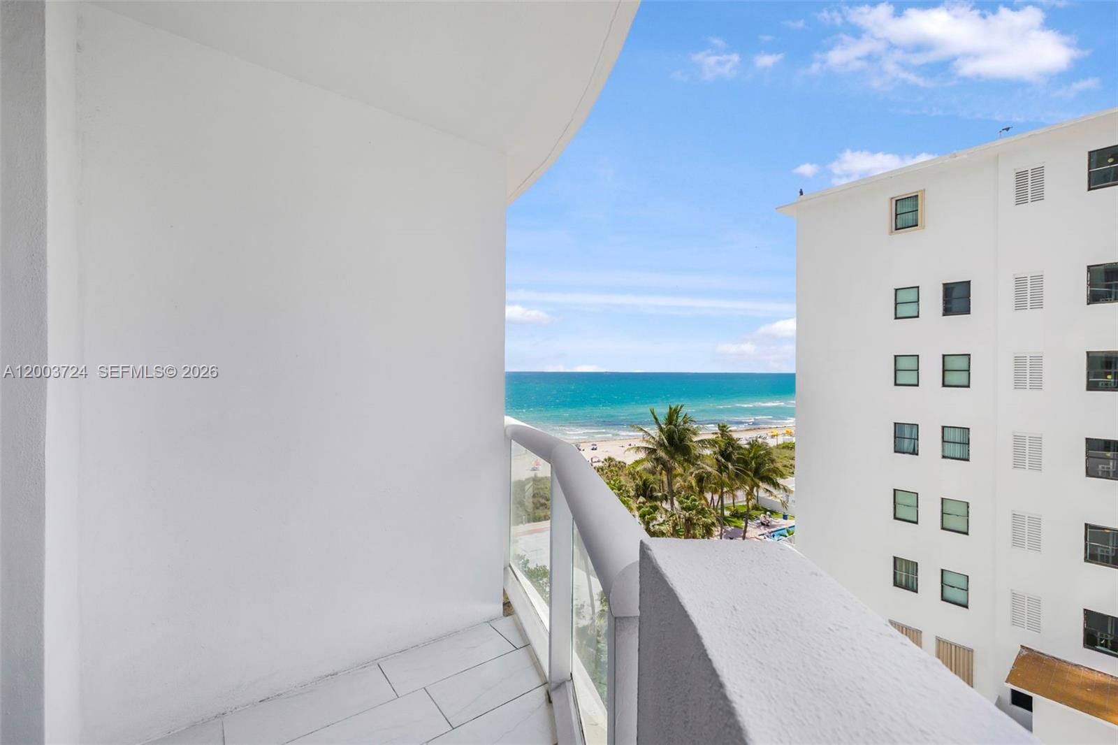 This open-concept living area features a dining set, a kitchen, and a balcony view — 6365 Collins Ave # 805, Miami Beach FL 33141, MIAMI BEACH, FL