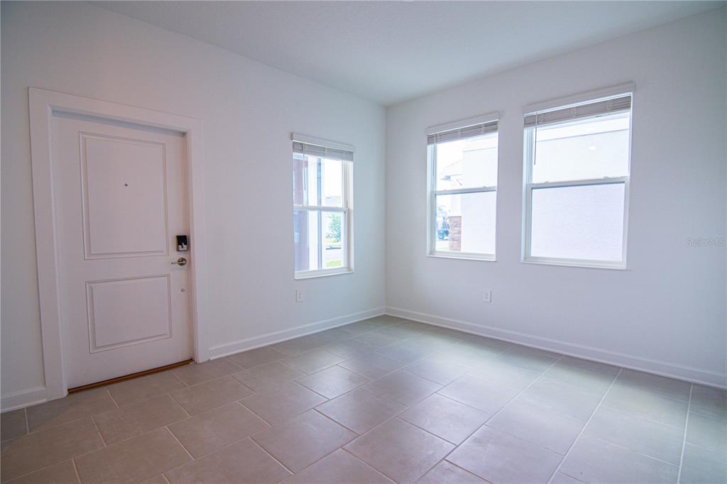 A bright room with white walls, tile flooring, a white door, and three windows — 3106 PARK VALE ROAD, ST CLOUD, FL
