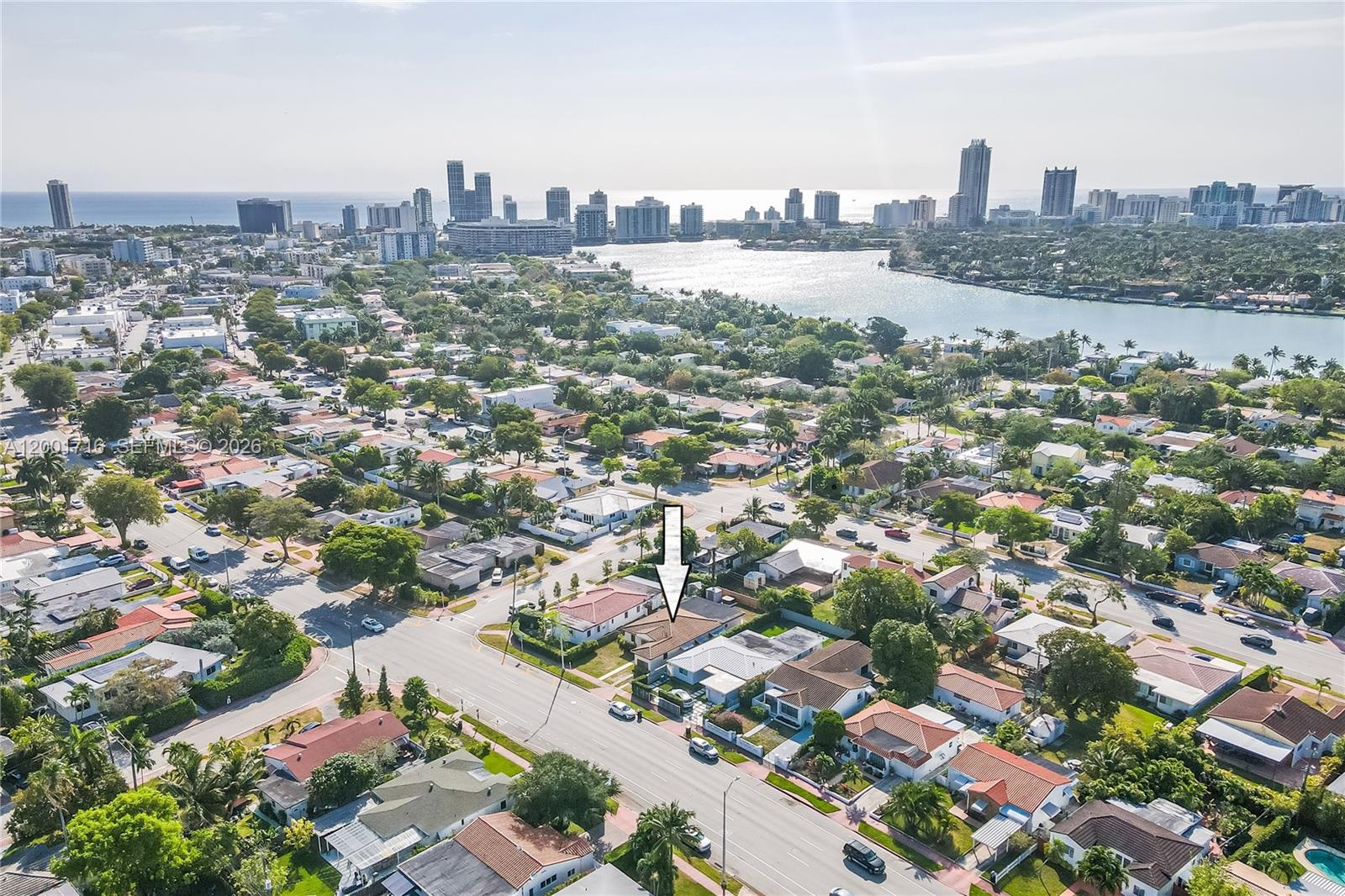 An aerial view shows a residential neighborhood with a marked house near a waterfront city — 1510 Normandy Dr # A, Miami Beach FL 33141, MIAMI BEACH, FL