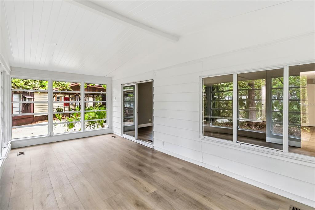 A sunroom with white walls, wood-look flooring, large windows, and a sliding glass door — 518 W PLANTATION BOULEVARD, LAKE MARY, FL