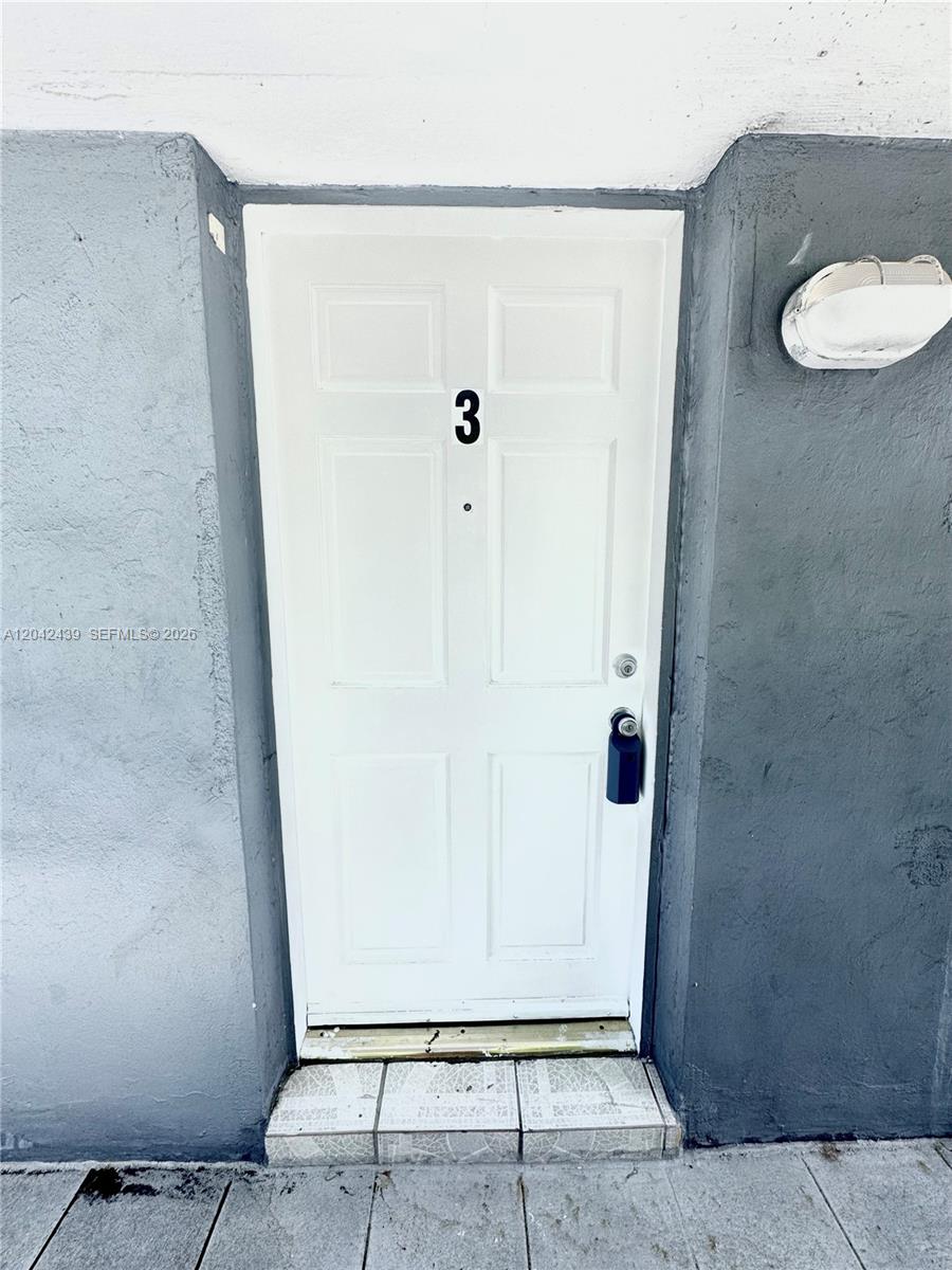 A white front door marked with the number three is set into a gray wall — 2732 SW 22nd STREET # 3, Miami FL 33133, MIAMI, FL