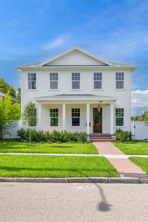 A two-story white house with a front porch, brick walkway, and green lawn — 1309 17TH AVENUE N, ST PETERSBURG, FL