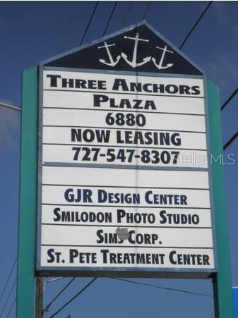A tall, rectangular sign for Three Anchors Plaza stands against a blue sky — 6880 46TH AVENUE N, ST PETERSBURG, FL