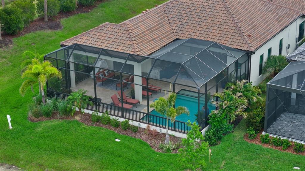 An aerial view of a house with a screened-in pool and patio area — 556 BOCELLI DRIVE, NOKOMIS, FL