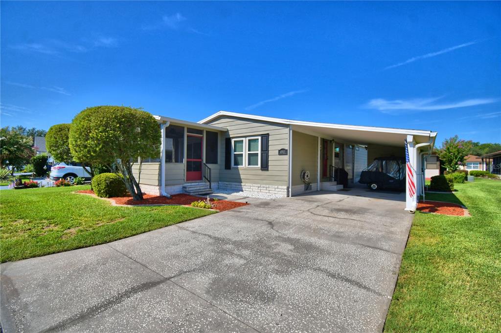 A single-story house with a carport, a screened-in porch, and a concrete driveway — 4901 COLONNADES CIRCLE E, LAKELAND, FL