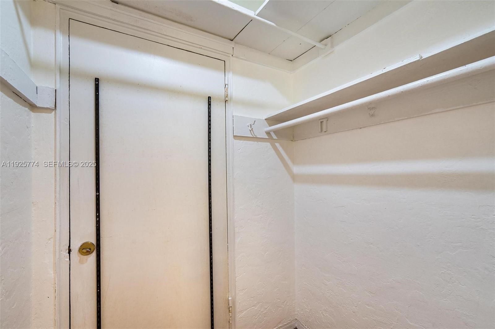 This interior view shows a small closet with white walls, a door, and shelving — 1611 Euclid Ave # 8, Miami Beach FL 33139, MIAMI BEACH, FL