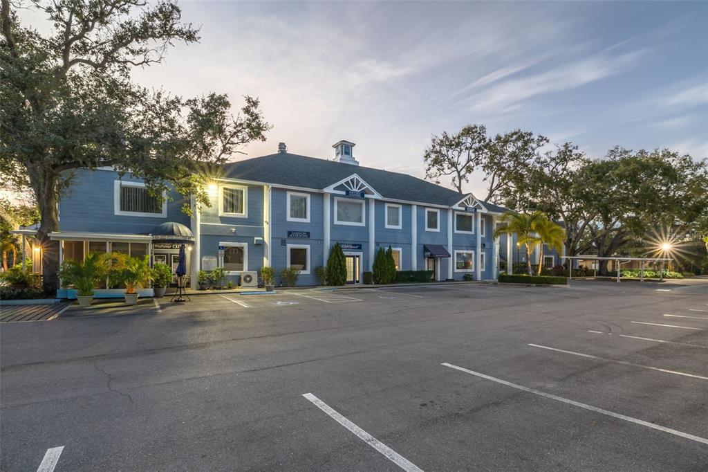 A two-story blue commercial building with a parking lot and surrounding trees — 1465 S FORT HARRISON AVENUE, CLEARWATER, FL