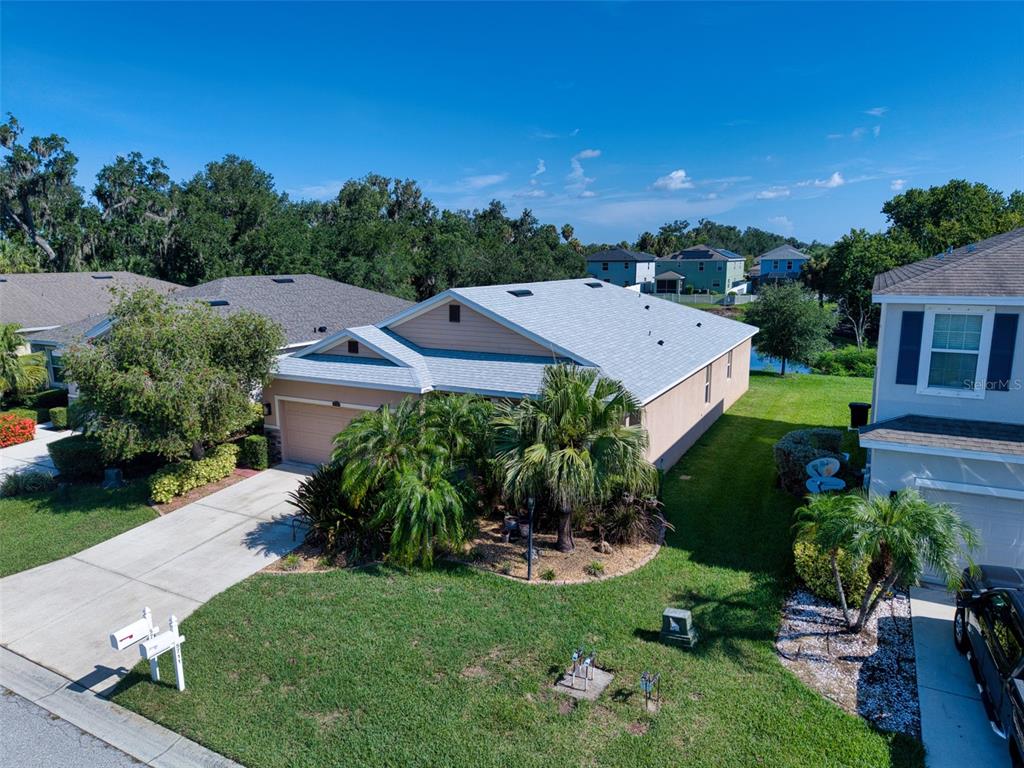 An aerial view shows a single-story house with a tan exterior and a gray roof — 5710 BROAD RIVER RUN, ELLENTON, FL