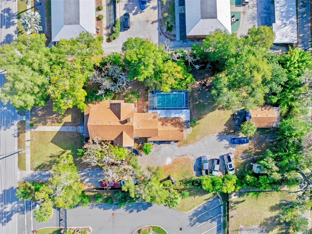 An aerial view shows a house with a brown roof, a pool, and a parking area — 228 W HOWRY AVENUE, DELAND, FL