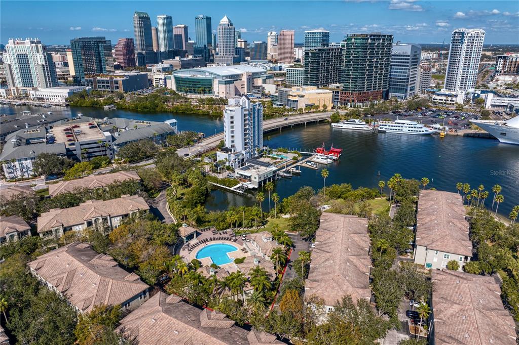 An aerial view shows a residential complex with a pool overlooking a river and city skyline — 751 CORAL REEF DRIVE, TAMPA, FL