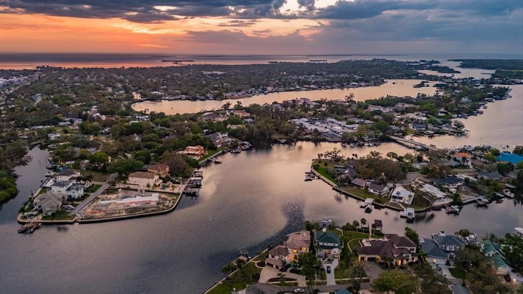 An aerial view of waterfront homes along a canal at sunset — 62 CENTRAL COURT, TARPON SPRINGS, FL