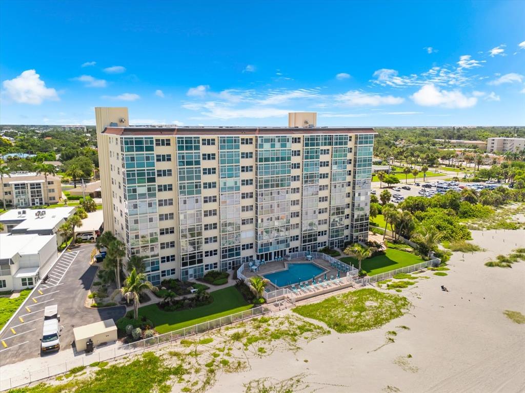 An aerial view of a multi-story beachfront condominium building with a swimming pool — 255 THE ESPLANADE N UNIT 701, VENICE, FL