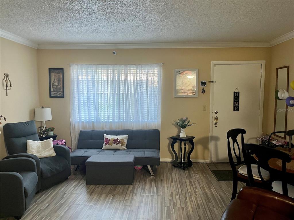 A living room features a gray sofa, a recliner, and light wood-look flooring — 123 BLUE POINT WAY UNIT 110, ALTAMONTE SPRINGS, FL