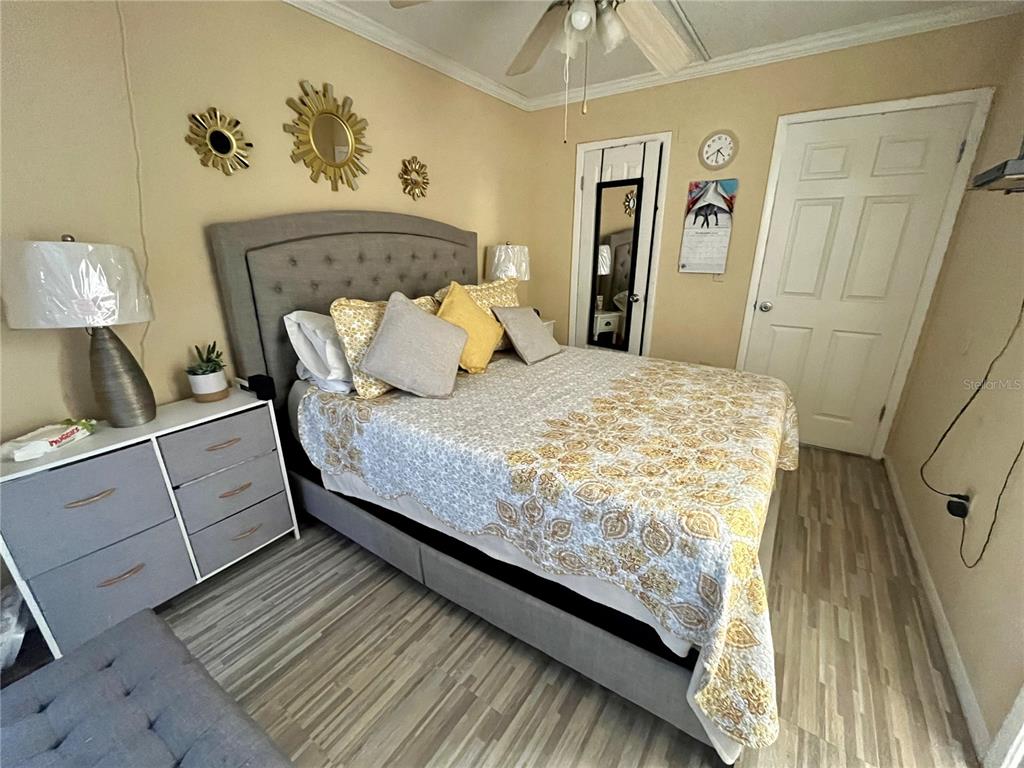 A bedroom features a tufted gray headboard, a patterned quilt, and a white dresser — 123 BLUE POINT WAY UNIT 110, ALTAMONTE SPRINGS, FL