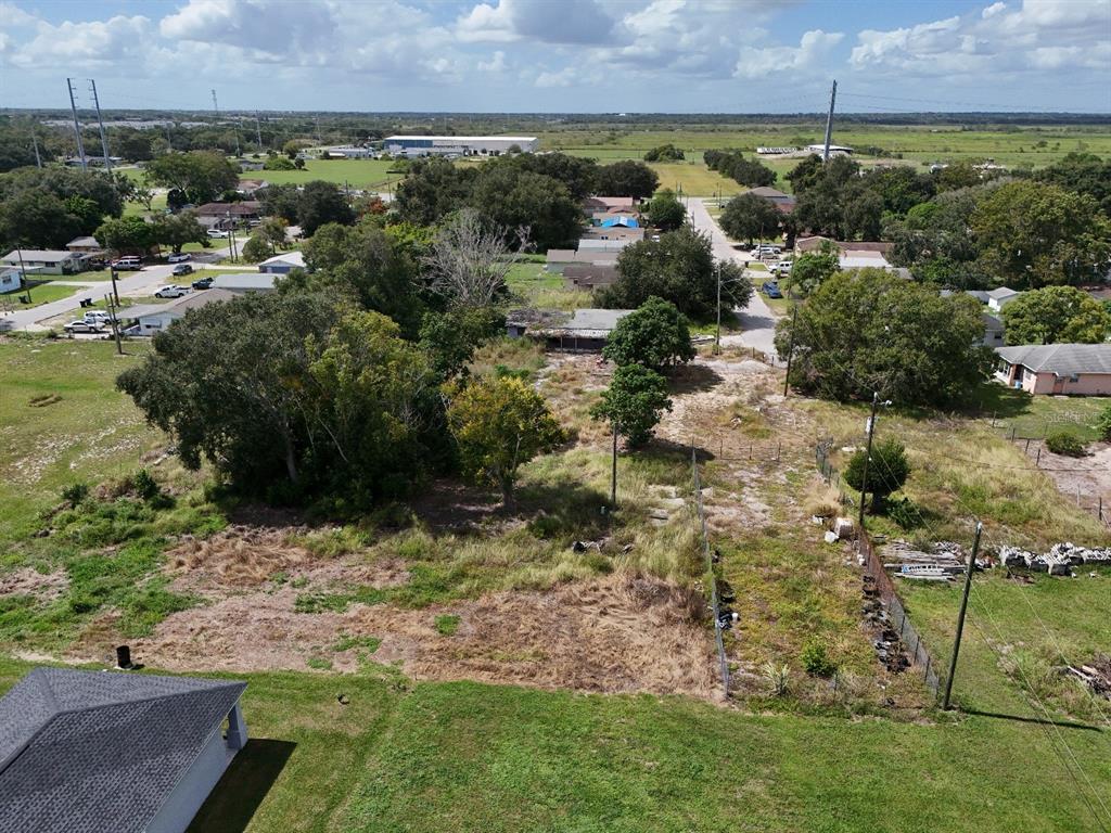 An aerial view shows a large, overgrown residential lot with a dilapidated house and trees — 219 SHEILA LANE, LAKE WALES, FL