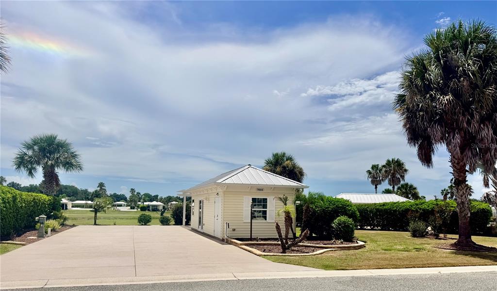 A small, light-colored building with a metal roof sits beside a concrete driveway — 9444 SE 49TH TERRACE, WEBSTER, FL
