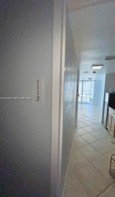 A view from a hallway looking into a bright apartment with tiled floors and balcony — 3301 NE 5th Ave # 1112, Miami FL 33137, MIAMI, FL