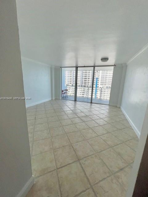 An empty room with light-colored tile flooring and a sliding glass door leading to a balcony — 3301 NE 5th Ave # 1112, Miami FL 33137, MIAMI, FL