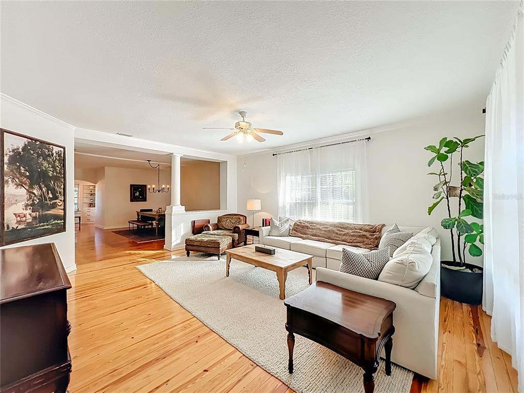 A living room features light wood floors, a white sectional sofa, and a ceiling fan — 1209 CLOUSER AVENUE, ORLANDO, FL