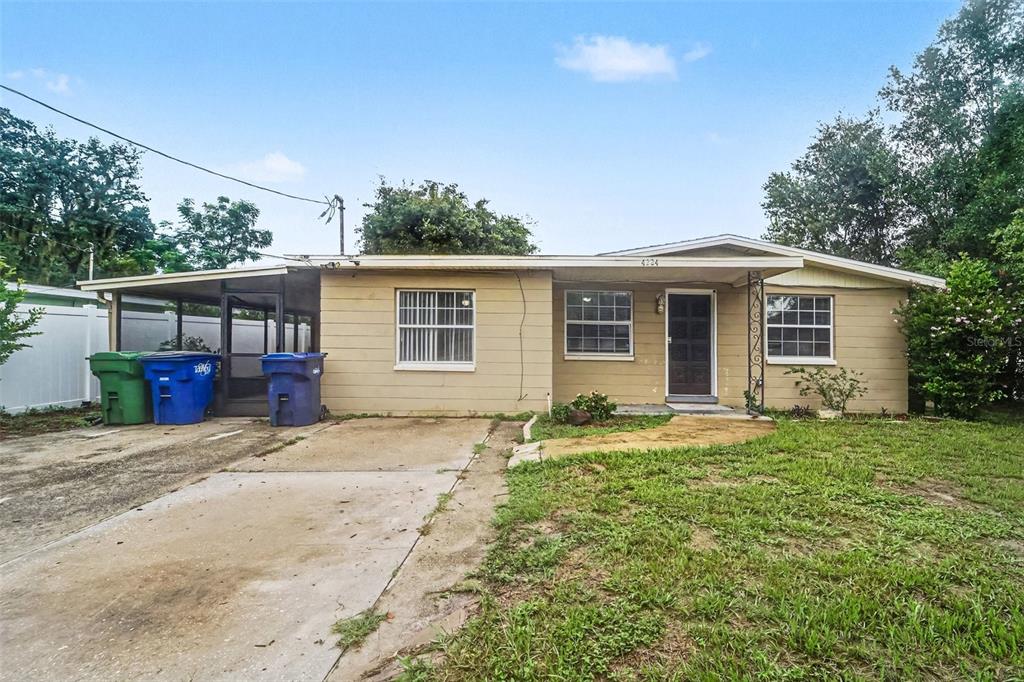 A single-story house with a tan exterior, a concrete driveway, and a covered carport — 4224 E REGNAS AVENUE, TAMPA, FL