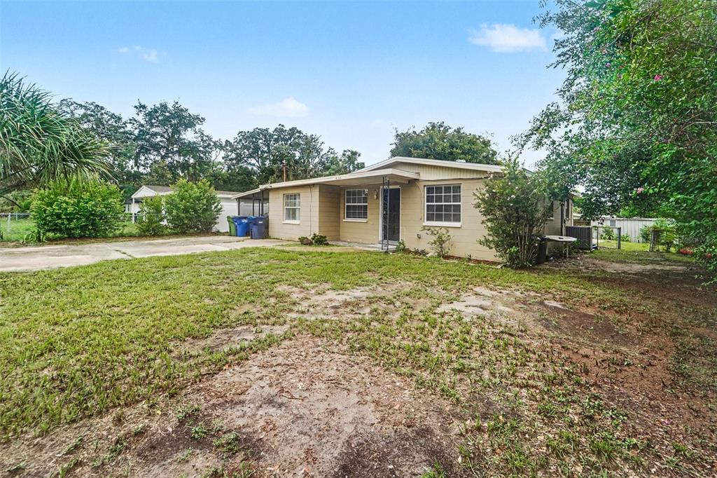 A single-story house with a tan exterior, a concrete driveway, and a grassy front yard — 4224 E REGNAS AVENUE, TAMPA, FL