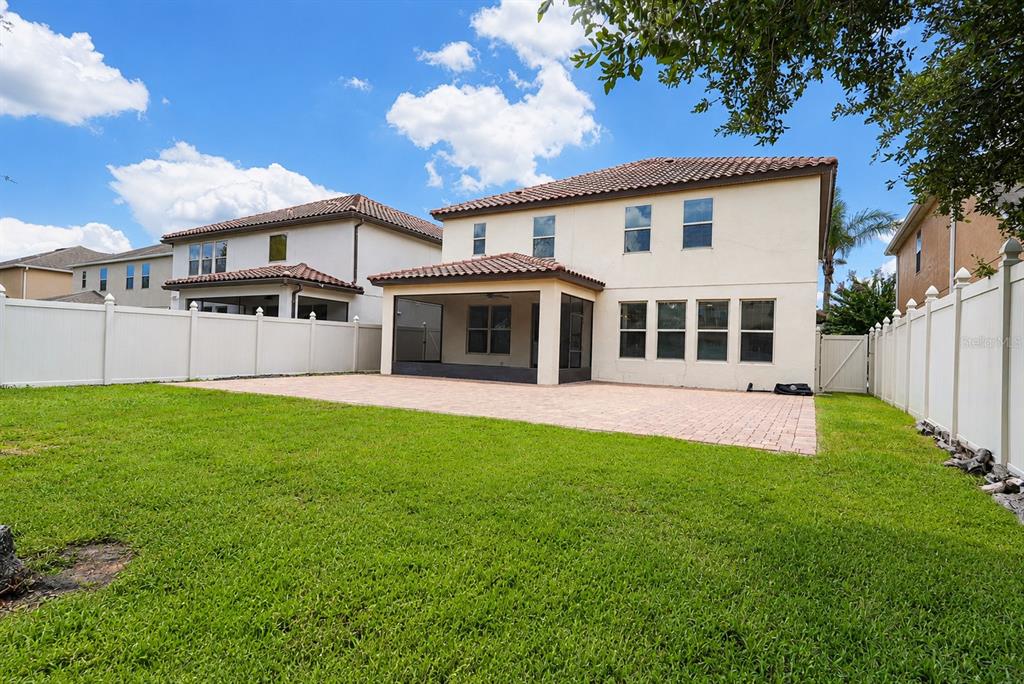 The backyard features a paved patio, a screened-in porch, and a white vinyl privacy fence — 9088 OUTLOOK ROCK TRAIL, WINDERMERE, FL