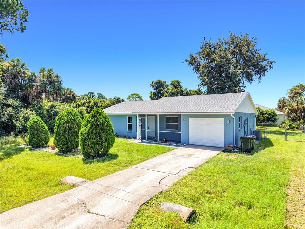A light blue single-story house with a white garage door and a concrete driveway — 4441 MULGRAVE AVENUE, NORTH PORT, FL
