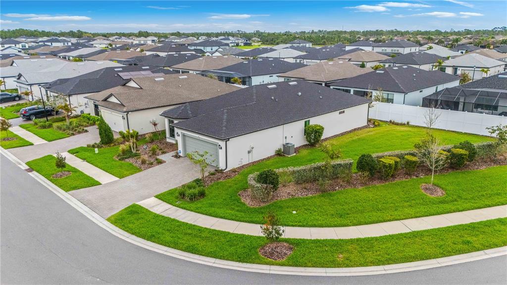 An aerial view shows a suburban house with a gray roof and driveway on a corner lot — 2414 GABEL OAK DRIVE, NORTH PORT, FL