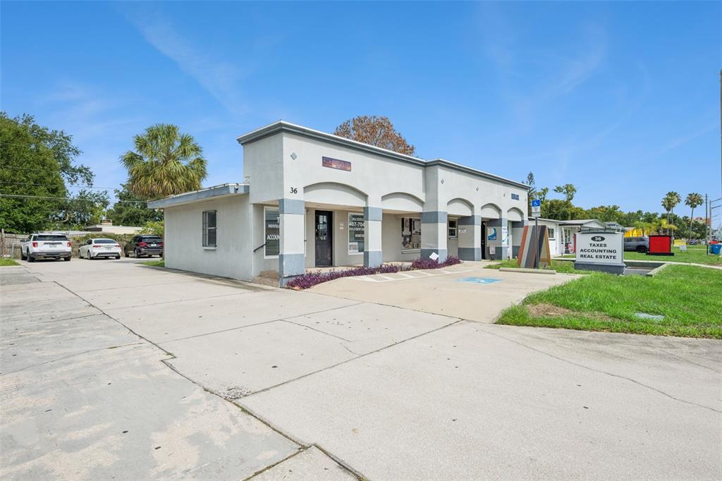A single-story commercial building with a concrete parking lot and a prominent signage board — 36 S SEMORAN BOULEVARD, ORLANDO, FL