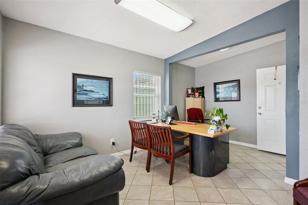 A home office features a leather sofa, a wooden desk with two chairs, and tile flooring — 36 S SEMORAN BOULEVARD, ORLANDO, FL