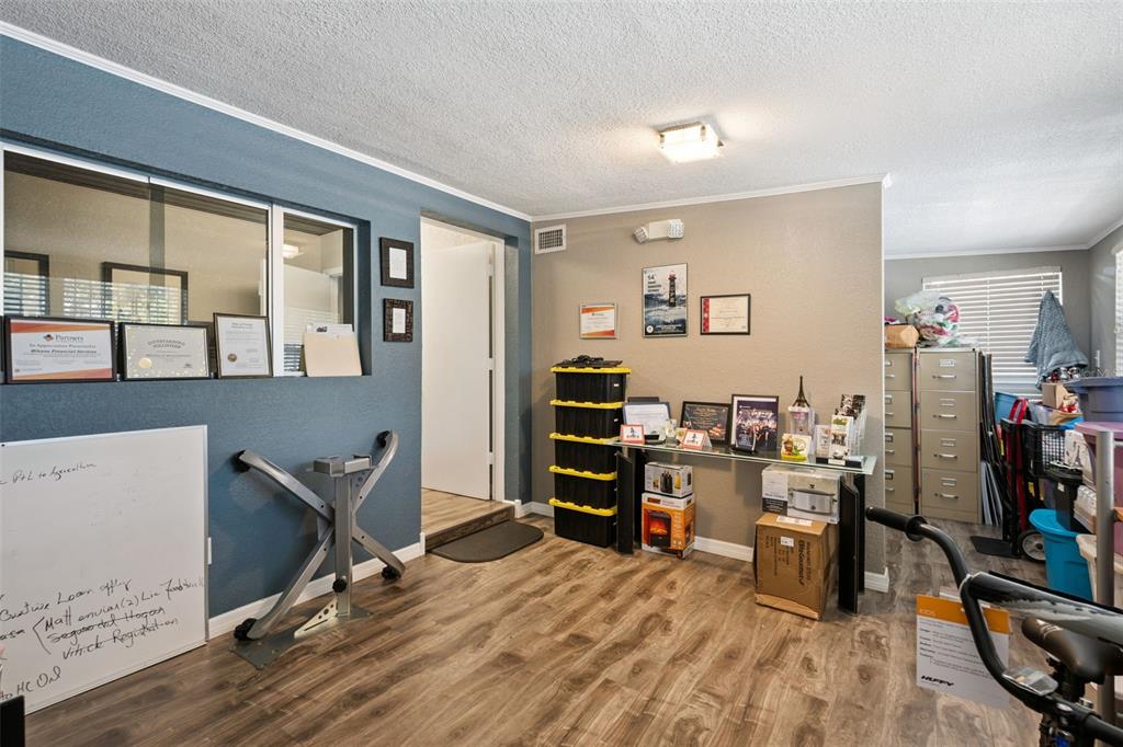 An office room features wood-look flooring, a blue accent wall, and a glass-topped console table — 36 S SEMORAN BOULEVARD, ORLANDO, FL