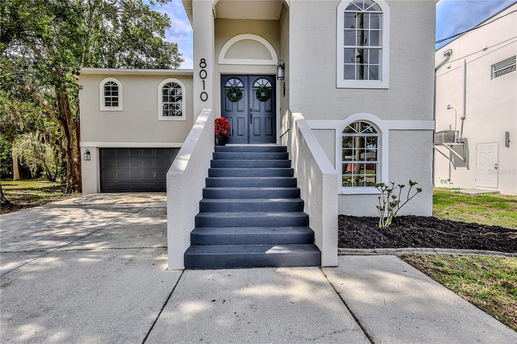 A two-story house features a dark gray front door, a staircase, and a garage — 8010 GULF WAY, HUDSON, FL