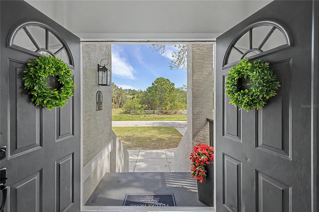 A two-story house with a gray exterior, a front-facing garage, and stairs leading to the entrance — 8010 GULF WAY, HUDSON, FL