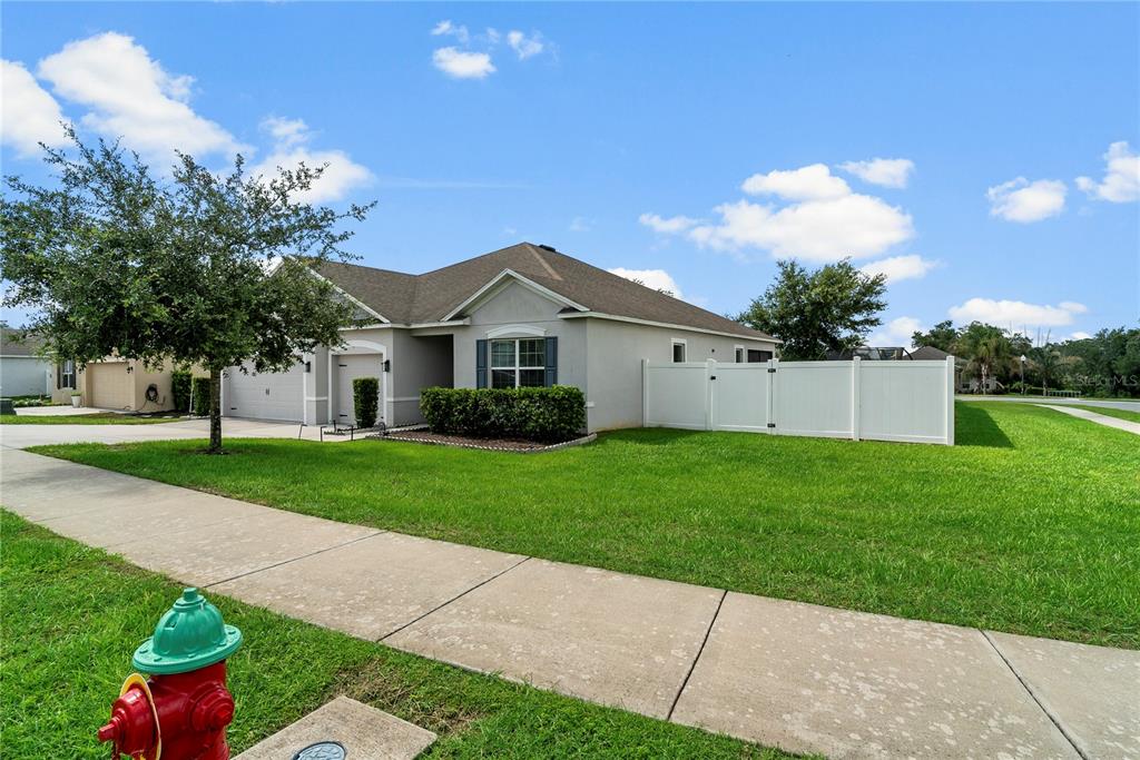 A single-story suburban house with a white vinyl fence and a red fire hydrant — 15266 AQUARIUS WAY, MASCOTTE, FL