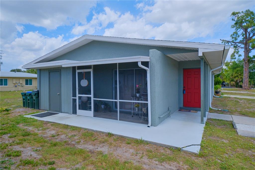 A single-story house with a screened-in porch and a bright red front door — 6231 CONISTON TERRACE, NORTH PORT, FL