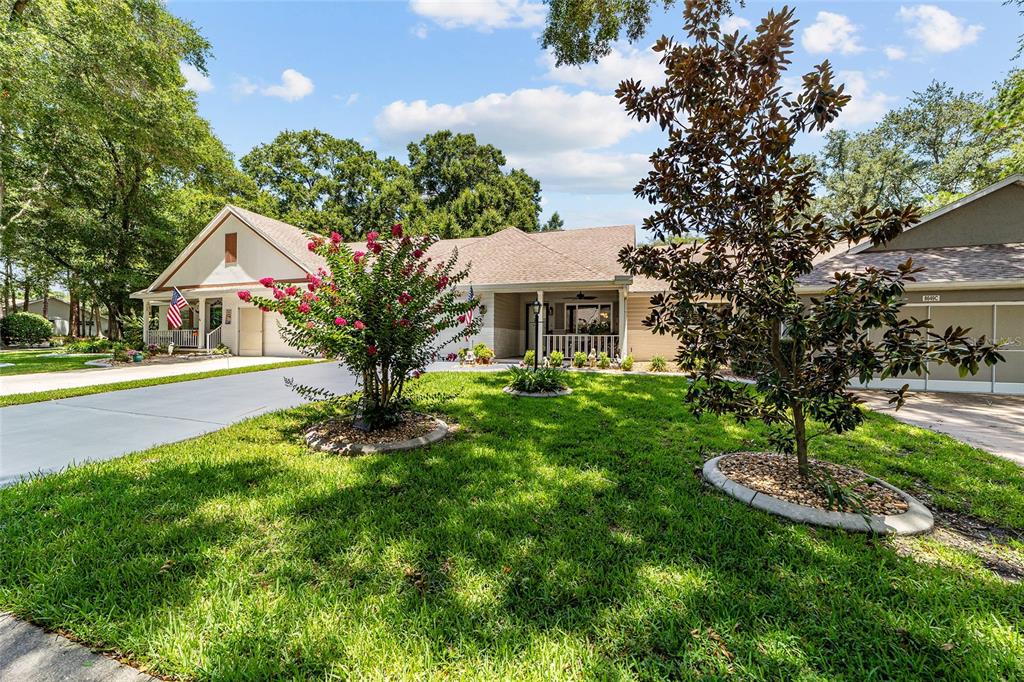 A single-story house with a light-colored exterior, a paved driveway, and two small trees — 8649 SW 92ND PLACE UNIT B, OCALA, FL
