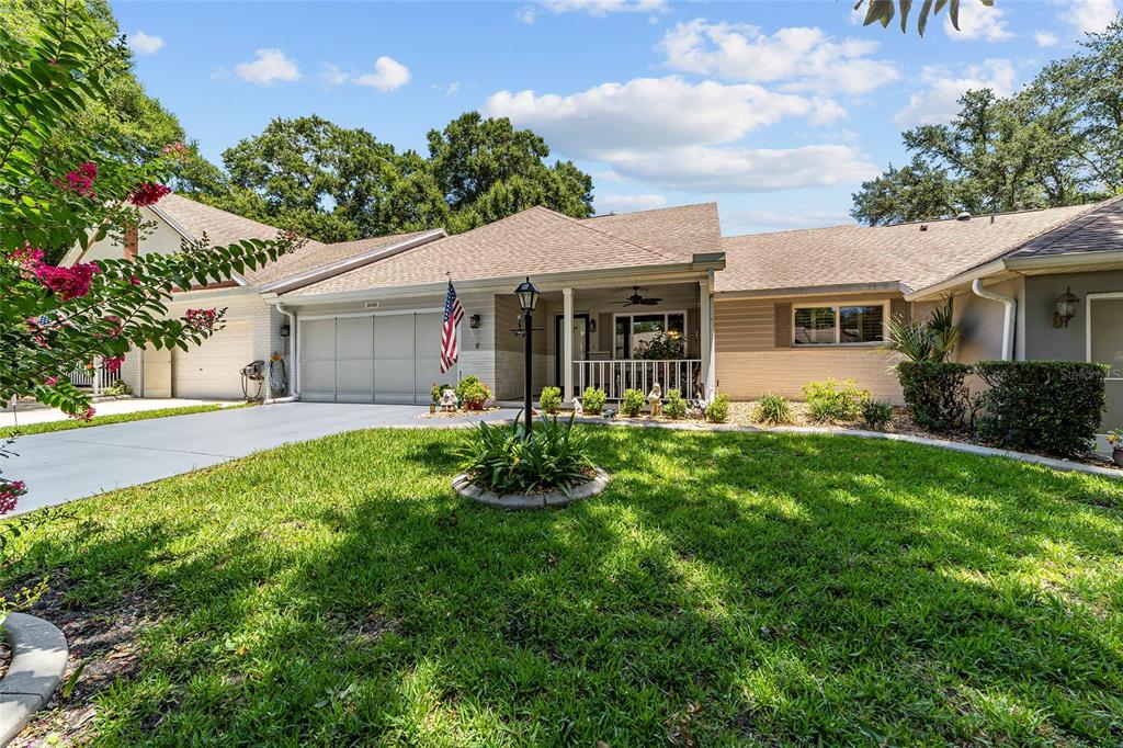 A single-story house with a two-car garage, a front porch, and a landscaped lawn — 8649 SW 92ND PLACE UNIT B, OCALA, FL