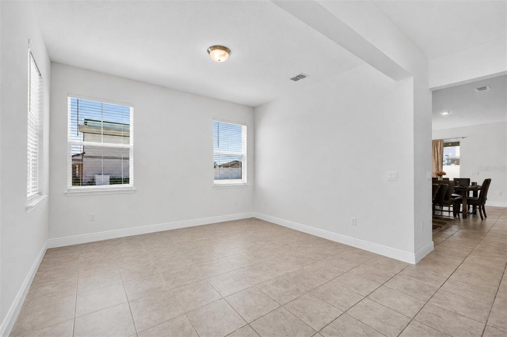 An empty room with white walls, tile flooring, and two windows — 2263 RAVEN RIDGE, CLERMONT, FL