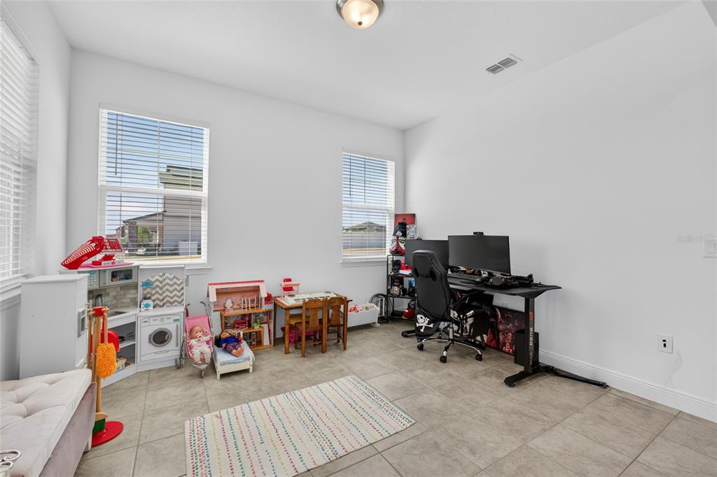 A multi-purpose room features tile flooring, two windows, a play area, and a computer desk — 2263 RAVEN RIDGE, CLERMONT, FL