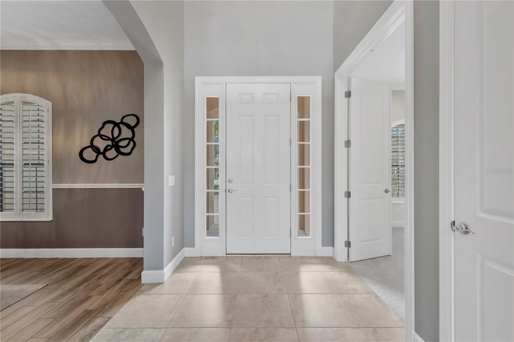 A tiled entryway features a white front door with sidelights and an adjacent open doorway — 9127 TILLINGHAST DRIVE, TAMPA, FL