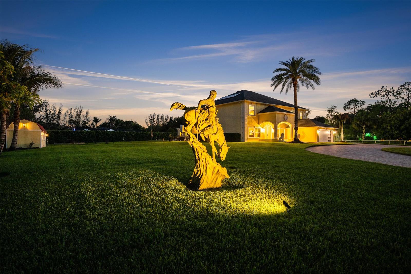 A large bronze statue of a bucking horse stands on a lawn before a house — 17948 N 33rd Rd Road N, FL 33470, FL