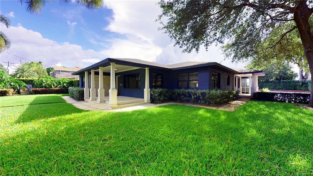 A dark blue single-story house features a covered front porch with white columns — 218 S MATANZAS AVENUE, TAMPA, FL