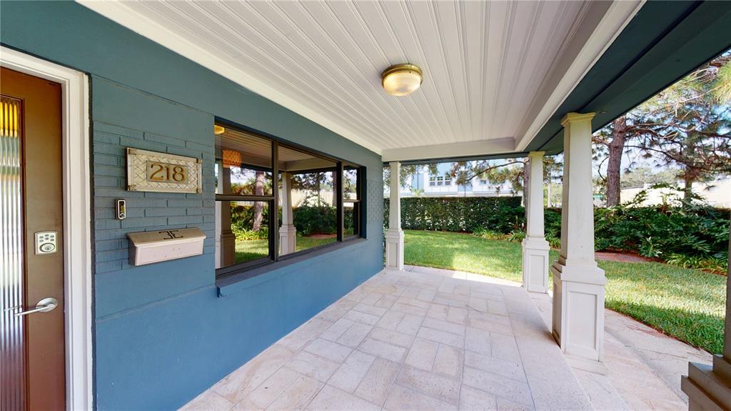 A covered porch with blue brick walls, a tile floor, and white support columns — 218 S MATANZAS AVENUE, TAMPA, FL
