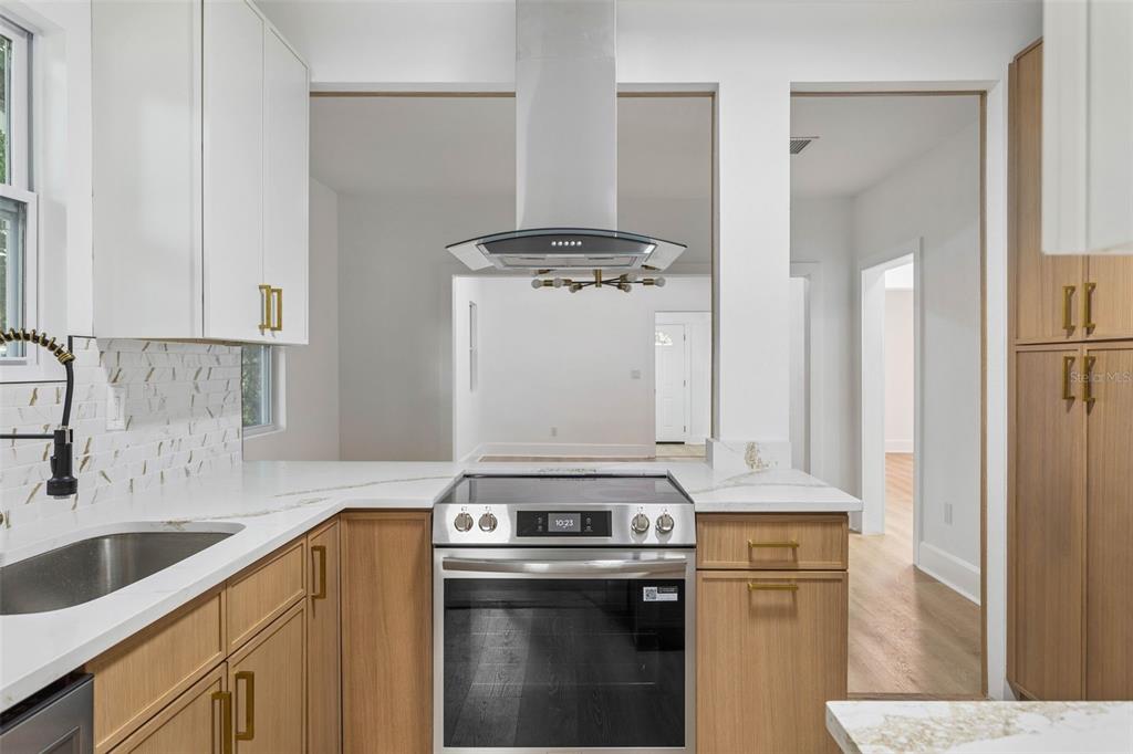 A kitchen features wood cabinets, white countertops, a stainless steel range, and a range hood — 4660 7TH AVENUE N, ST PETERSBURG, FL
