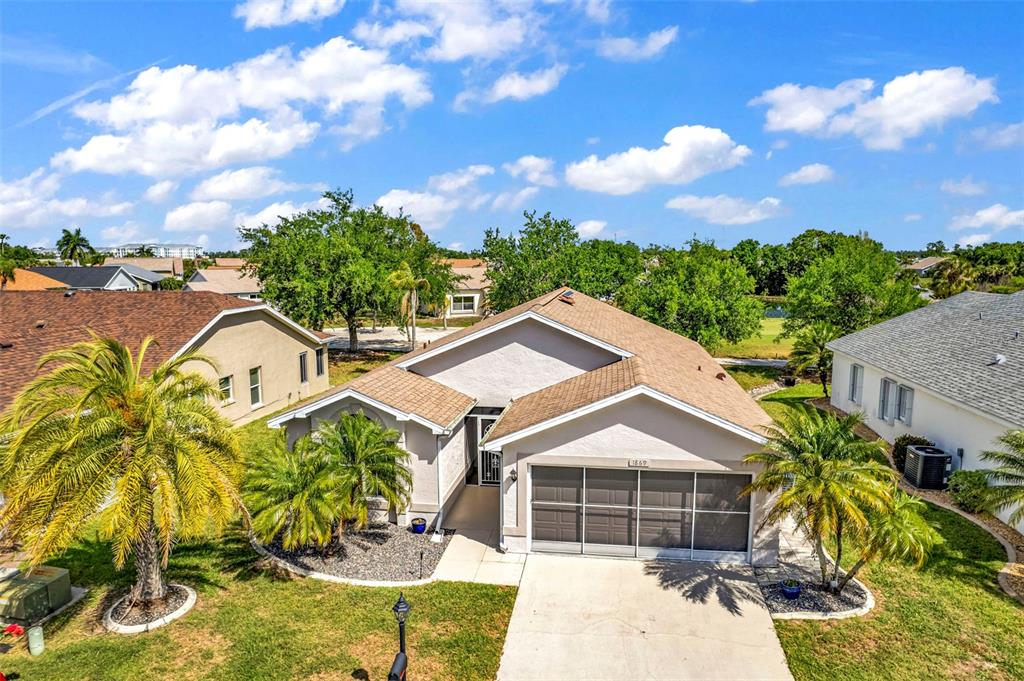 An aerial view of a single-story suburban house with a screened garage and palm trees — 1869 BIRMINGHAM BOULEVARD, PUNTA GORDA, FL